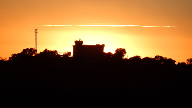 Genau hinter der Burg versinkt die Sonne.