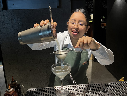 Sie fabriziert einen Pisco Sour.